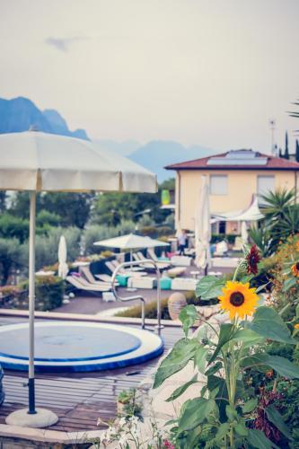 a swimming pool with an umbrella and a sunflower at Villa Treccani Apartments in Malcesine