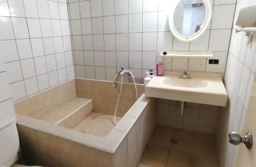 a bathroom with a tub and a sink and a shower at 知本溫泉-彩溱旅宿 in Wenquan