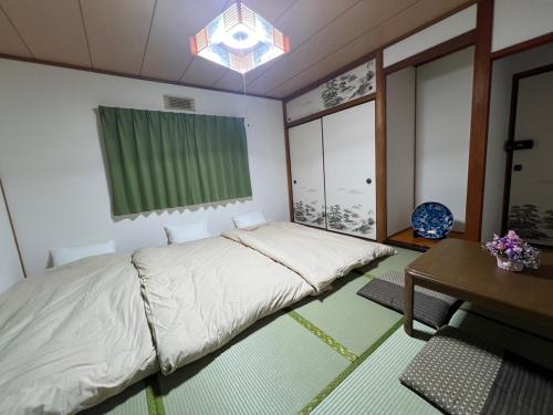 a bedroom with a bed and a desk and a table at 幸の小江戸ハウス in Kawagoe