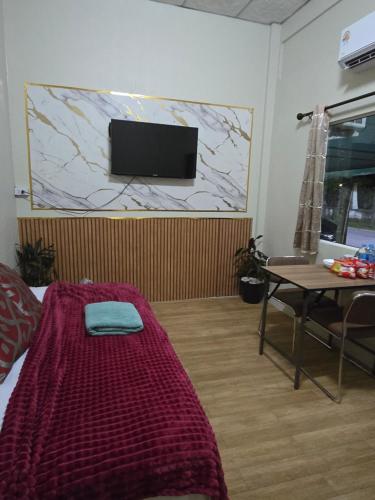 a room with a bed and a table and a flat screen tv at Near Central Hatyai#Asean Night Bazaar Market in Hat Yai