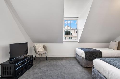 a bedroom with two beds and a tv and a window at Millers on Kent III - Perfect Abode for 10 people in Sydney