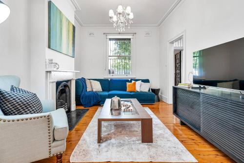 a living room with a blue couch and a table at Millers on Kent III - Perfect Abode for 10 people in Sydney