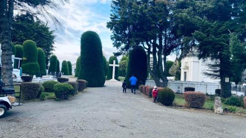 a group of people walking through a garden at Hostal Yei, Punta Arenas in Punta Arenas