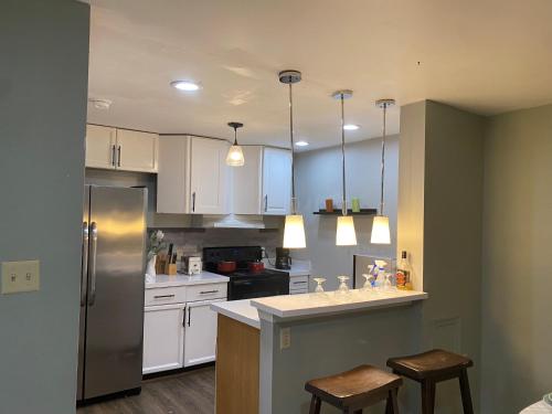 a kitchen with white cabinets and a stainless steel refrigerator at The Big Beautiful Townhouse in Frederick