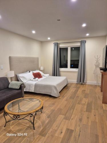 a bedroom with a bed and a couch and a table at Gabby's Place Downtown Core in Toronto