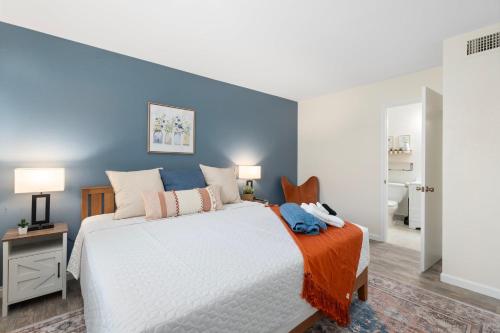 a bedroom with a white bed and a blue wall at Button Bungalow Spring Fun & Golfing Hot Tub BBQ in Mesa
