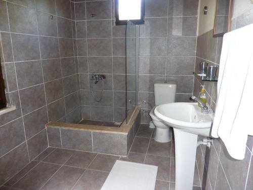 a bathroom with a shower and a toilet and a sink at Misafir Evi in Kayakoy