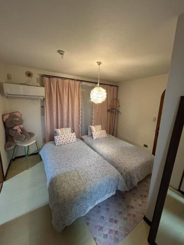 a bedroom with two beds and a chandelier at JOY HOUSE Near Ikebukuro in Tokyo