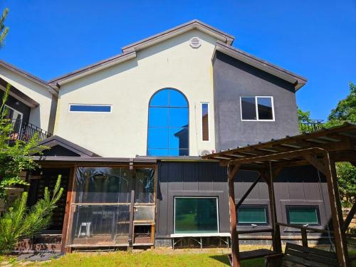 a house with a blue window on the side of it at Poam Mountain Pool Villa Pension in Mungyeong