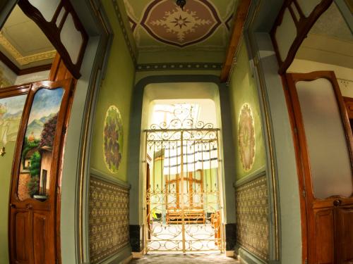プエブラにあるAzcami Boutique Hotelの緑の壁と木の扉が施された入口
