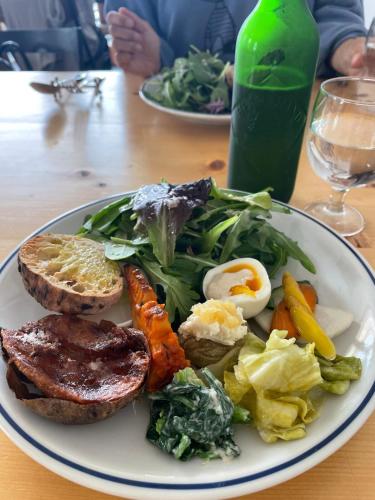 a plate of food with eggs and vegetables on a table at Ocean Flat 江ノ島鵠沼海岸 in Fujisawa