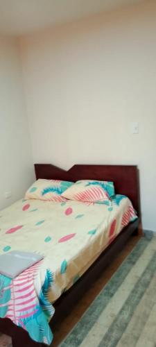 a bed with colorful sheets and pillows on it at Habitaciones cerca al aeropuerto& alojamiento &apartaestudio in Palmira