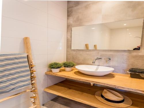 Un baño con lavabo, espejo y toallas. en Bungalow near Dutch Coast & Forest, en Noordwijk