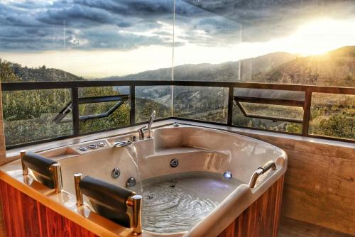 a bathroom with a bath tub in front of a window at El Encanto - La Trinidad, cabaña con jacuzzi in Duitama