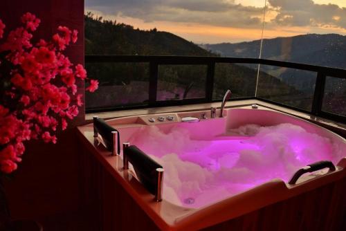 a purple bath tub with a view of a mountain at El Encanto - La Trinidad, cabaña con jacuzzi in Duitama