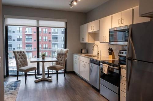 a kitchen with a table and two chairs and a sink at Sleepover Iconic Des Moines Apartments in Des Moines