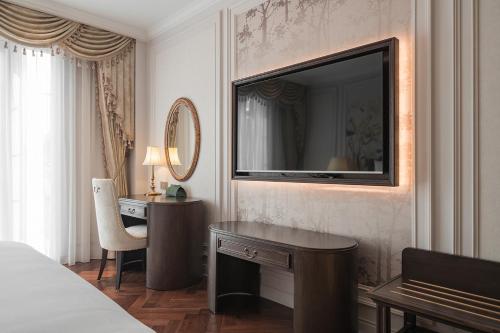 a hotel room with a desk and a mirror at Golden Sun Hotel - Dalat in Da Lat