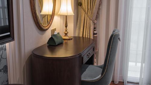 a desk in a room with a lamp and a chair at Golden Sun Hotel - Dalat in Da Lat