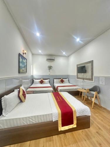 a bedroom with two beds and a tv at Tiến Đạt Hotel Vũng Tàu in Vung Tau
