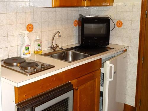 une cuisine avec un évier et un micro-ondes dans l'établissement Studio pour 2 avec WiFi - Les Gets Centre - FR-1-802-97, aux Gets