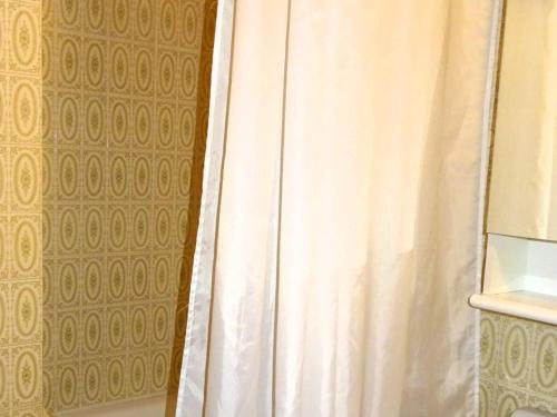 La salle de bains est pourvue d'une douche avec un rideau de douche blanc. dans l'établissement Studio pour 2 avec WiFi - Les Gets Centre - FR-1-802-97, aux Gets