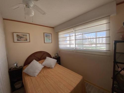 - une chambre avec un lit avec deux oreillers et une fenêtre dans l'établissement Appartement 2 pièces 5 pers avec Parking au Barcarès - FR-1-81-643, au Barcarès