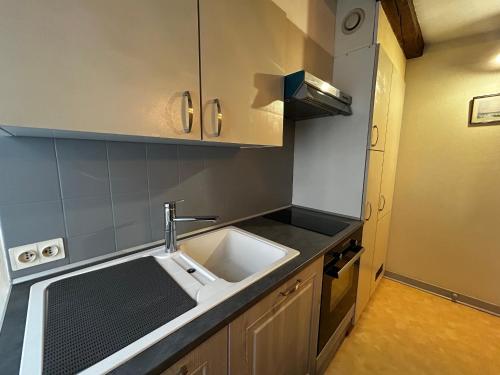 une cuisine avec un évier et une cuisinière dans l'établissement Charmant T2 au centre de La Roche-Posay avec WIFI et parking gratuit - FR-1-541-163, à La Roche-Posay