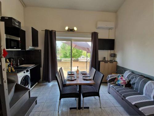 une cuisine et un salon avec une table et un canapé dans l'établissement Appartement bord de mer avec terrasse, parking, animaux acceptés - FR-1-387-215, à Marseillan