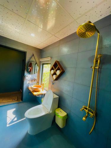 a blue bathroom with a toilet and a shower at Bình An House in Sapa