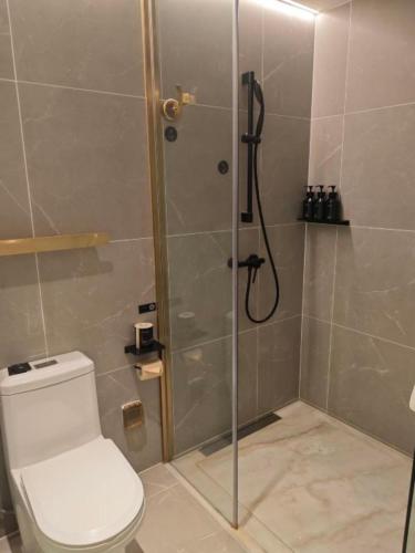 a bathroom with a shower with a toilet and a glass door at Atour Light Hotel Beijing Guang'anmen in Beijing