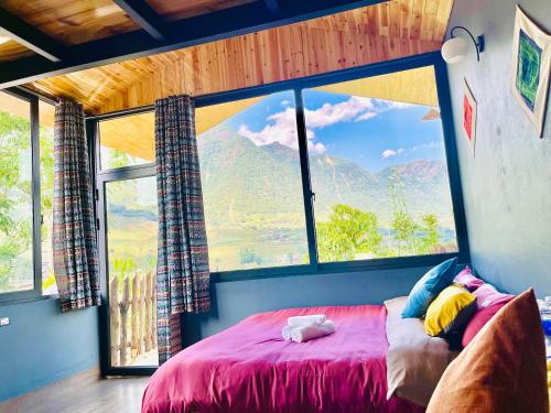 a bedroom with a large window with a large bed at Bình An House in Sapa