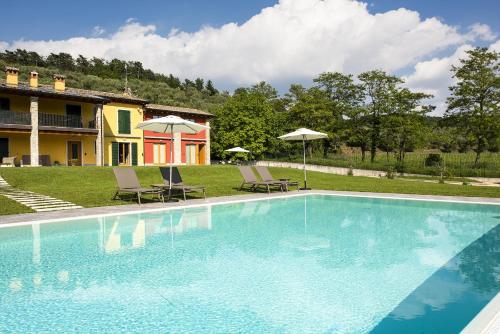 a swimming pool with two chairs and a house at Rovertondo in Costermano