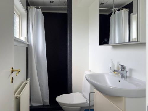 a bathroom with a sink and a toilet and a mirror at Central Trshavn Apartment in Tórshavn
