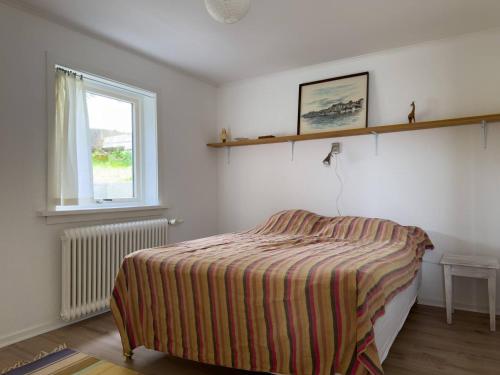 a small bedroom with a bed and a window at Central Trshavn Apartment in Tórshavn