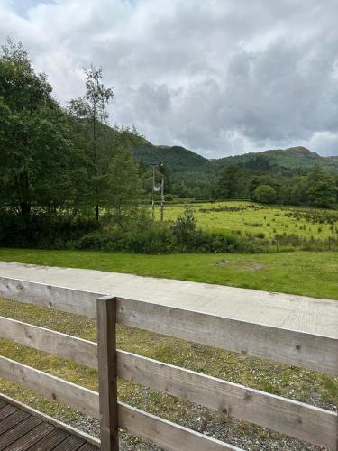 a wooden fence with a view of a field at 77 Glenfinart Caravan Park in Dunoon