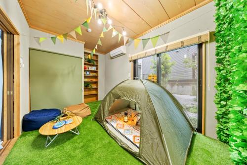 a room with a tent and a table at 親子で遊べるボルダリングやボールプール付きの貸し切りアパート 国立駅徒歩4分 in Kunitachi