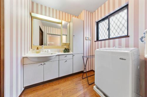 a bathroom with a sink and a mirror at 親子で遊べるボルダリングやボールプール付きの貸し切りアパート 国立駅徒歩4分 in Kunitachi