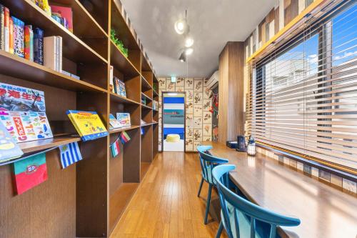 a library with blue chairs and bookshelves at 親子で遊べるボルダリングやボールプール付きの貸し切りアパート 国立駅徒歩4分 in Kunitachi