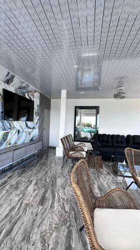 a living room with a couch and a tv at Hotel Costa Norte in Necoclí