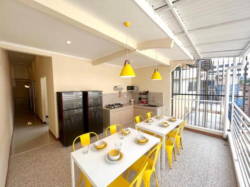 une cuisine avec des chaises et des tables jaunes dans une pièce dans l'établissement Premium Guest House Harmoni Jakarta pusat - Free Wifi & Smart tv Facility, à Jakarta