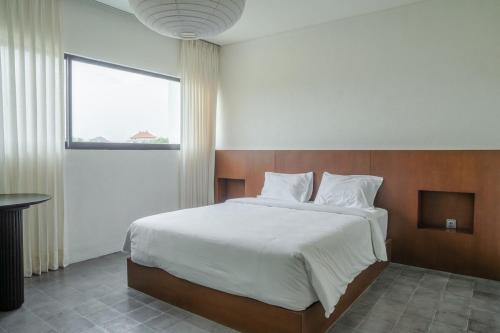 a bedroom with a large bed and a window at Jena Studio Villa in Cemagi