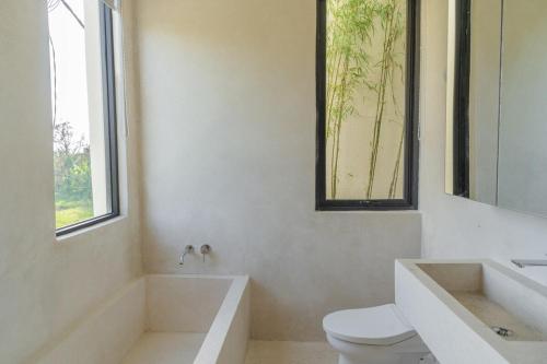 a bathroom with a tub and a toilet and a sink at Jena Studio Villa in Cemagi