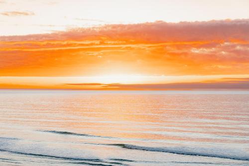 a sunset over a body of water at Oceanview Suite in Hapuku