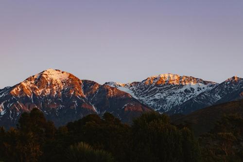 a group of mountains with snow on them at Oceanview Suite in Hapuku