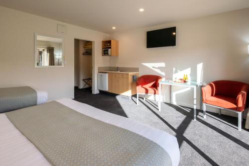 a hotel room with a bed and a desk and a chair at Hanmer Springs Gateway Lodge in Hanmer Springs