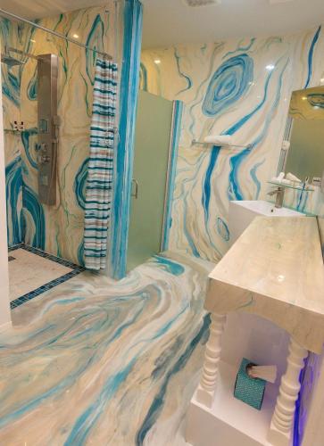 a bathroom with a wave patterned floor and a sink at Luxury Puerto Caribe Boutique Hotel in Aguada