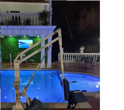 a crane stands next to a swimming pool at night at Luxury Puerto Caribe Boutique Hotel in Aguada
