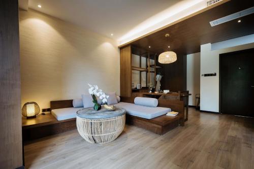 a living room with a couch and a table at 青城山坐忘森林疗愈酒店 in Dujiangyan