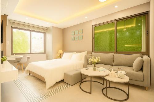 a hotel room with a bed and a couch at Ben's Signature Hotel and Residence - Hanoi Center in Hanoi