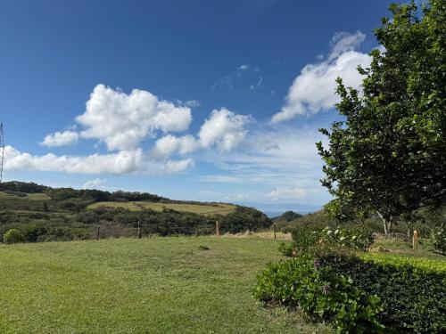 a field of grass with a blue sky and clouds at Campo Azul #3 - Monteverde in Monteverde Costa Rica